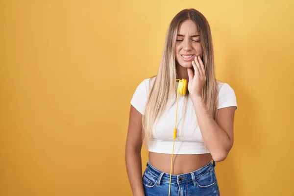Junge Blonde Frau Die Vor Gelbem Hintergrund Steht Und Kopfhörer — Stockfoto
