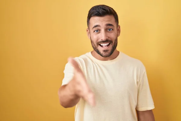 Pohledný Hispánec Stojící Nad Žlutým Pozadím Přátelsky Usmívající Nabízející Pozdrav — Stock fotografie