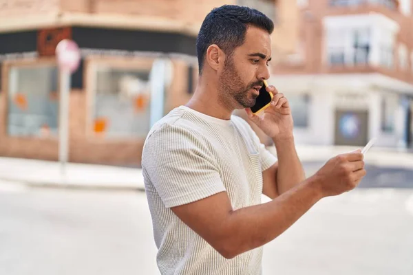 Young Hispanic Man Talking Smartphone Using Credit Card Street — Stock fotografie