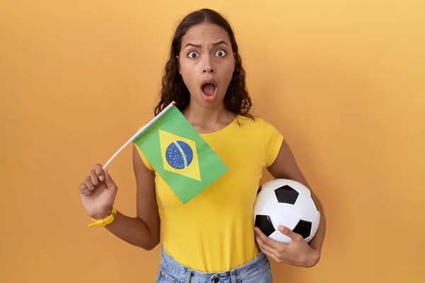Молодая Латиноамериканка Бразильским Флагом Футбольным Мячом Руках Выглядящая Скептически Саркастично — стоковое фото
