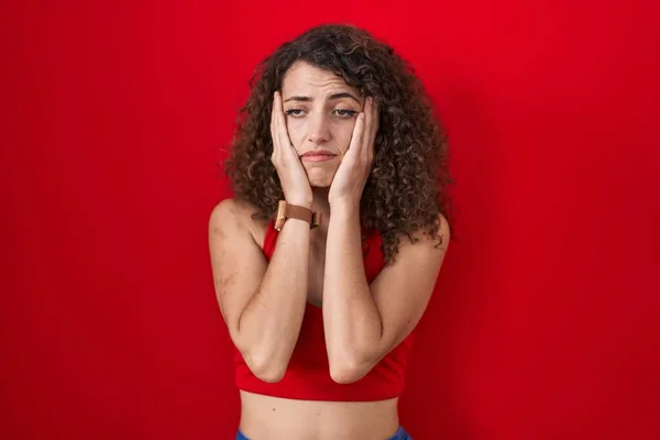 Kıvırcık Saçlı Spanyol Kadın Kırmızı Arka Planda Duruyor Yorgun Eller — Stok fotoğraf