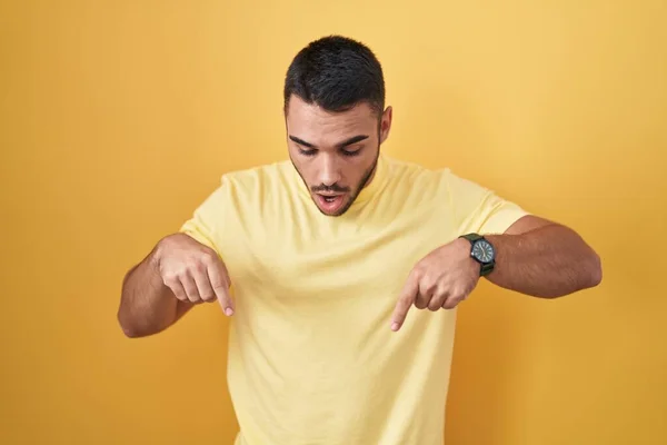 Young Hispanic Man Standing Yellow Background Pointing Fingers Showing Advertisement — Stockfoto