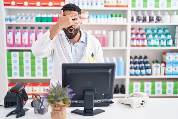 Латиноамериканец Бородой Работающий Аптеке Подглядывающий Рукой Шокирующее Лицо Глаза Смотрящий — стоковое фото