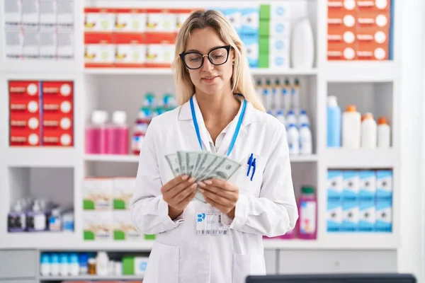 Young Blonde Woman Pharmacist Smiling Confident Counting Dollars Pharmacy — ストック写真