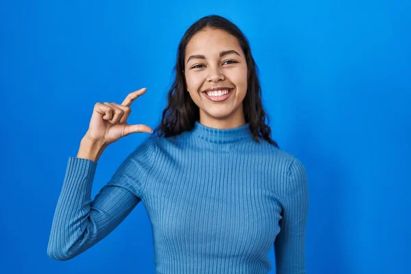 Jonge Braziliaanse Vrouw Staat Blauwe Geïsoleerde Achtergrond Glimlachend Zelfverzekerd Gebaar — Stockfoto