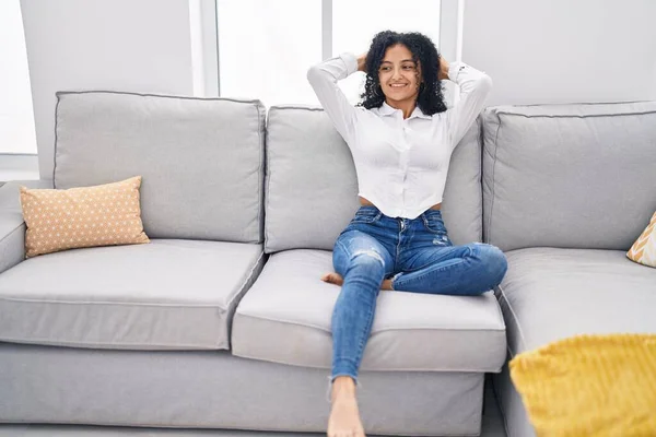 Young Hispanic Woman Relaxed Hands Head Sitting Sofa Home — Stock fotografie
