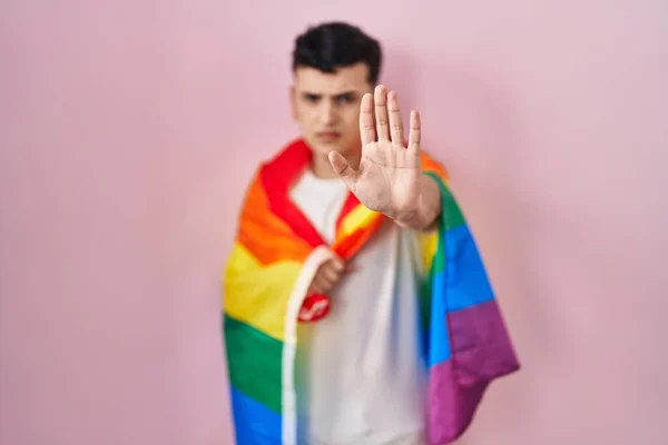 虹のLgbtqフラグを保持している非バイナリ人で 手を開いて真剣に 自信を持って表現 防衛ジェスチャーで停止記号を行う — ストック写真