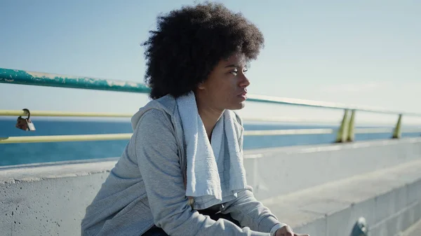 stock image African american woman wearing sportswear sitting on bench at seaside