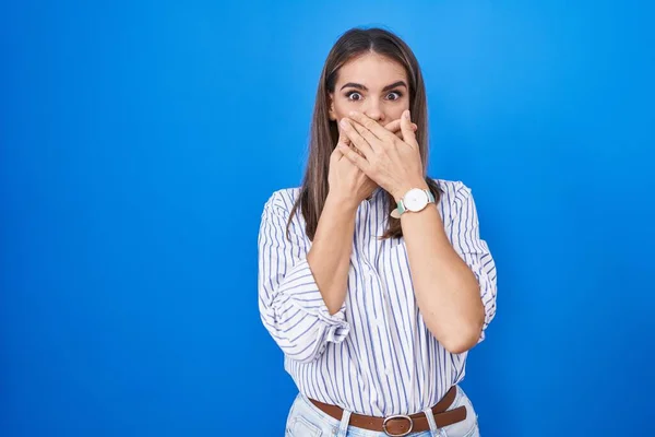 Hispanic Young Woman Standing Blue Background Shocked Covering Mouth Hands — ストック写真