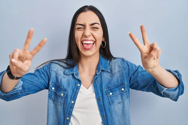 Eine Spanierin Die Vor Blauem Hintergrund Steht Lächelt Mit Herausgestreckter — Stockfoto