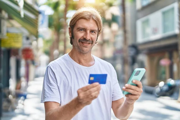 Mladý Blond Muž Pomocí Smartphone Kreditní Karty Ulici — Stock fotografie