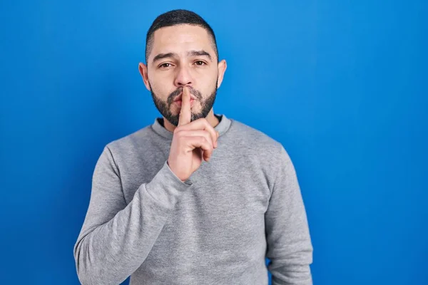 Hombre Hispano Pie Sobre Fondo Azul Pidiendo Silencio Con Dedo — Foto de Stock