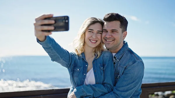 男と女のカップル立ち一緒に作る自画によってスマートフォンで海辺 — ストック写真