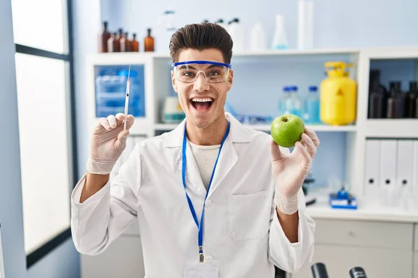 Jeune Homme Hispanique Travaillant Laboratoire Scientifique Tenant Pomme Célébrant Fou — Photo