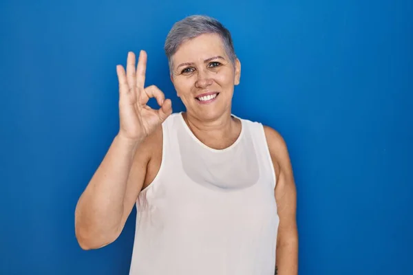 Medelålders Kaukasiska Kvinna Står Över Blå Bakgrund Ler Positivt Gör — Stockfoto