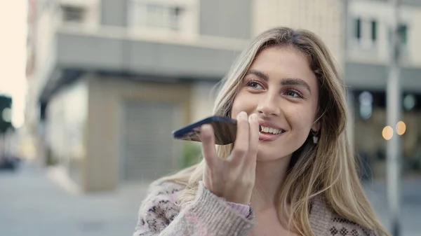 stock image Young blonde woman smiling confident sending voice message by smartphone at street