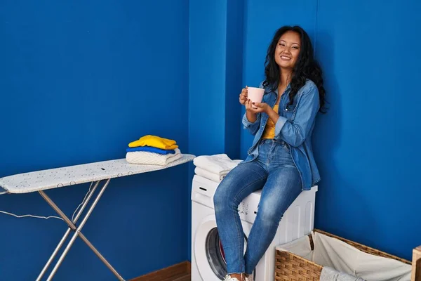 Young Chinese Woman Drinking Coffee Waiting Washing Machine Laundry Room — Fotografia de Stock
