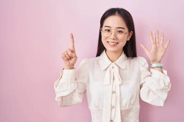 Mladá Číňanka Stojící Nad Růžovým Pozadím Ukazující Ukazující Nahoru Prsty — Stock fotografie