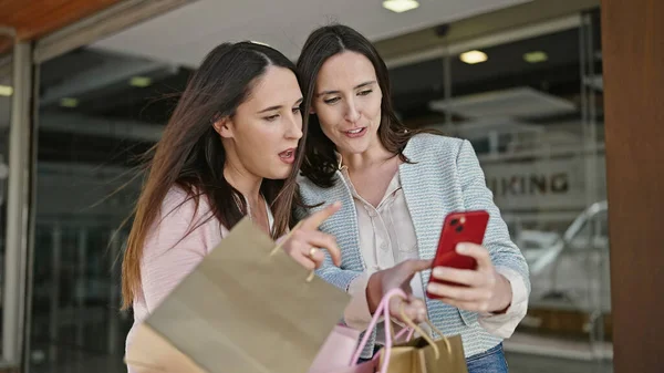Duas Mulheres Vão Compras Segurando Sacos Usando Smartphone Rua — Fotografia de Stock