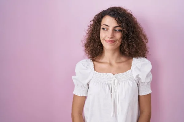 Hispanic Woman Curly Hair Standing Pink Background Smiling Looking Side — Stock fotografie