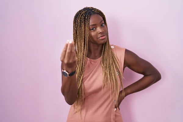 拥有辫子的非洲裔美国女人站在粉色的背景上 手指手画脚地做着意大利式的手势 — 图库照片