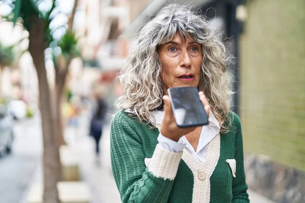 中世の女性が路上でスマートフォンで話している — ストック写真