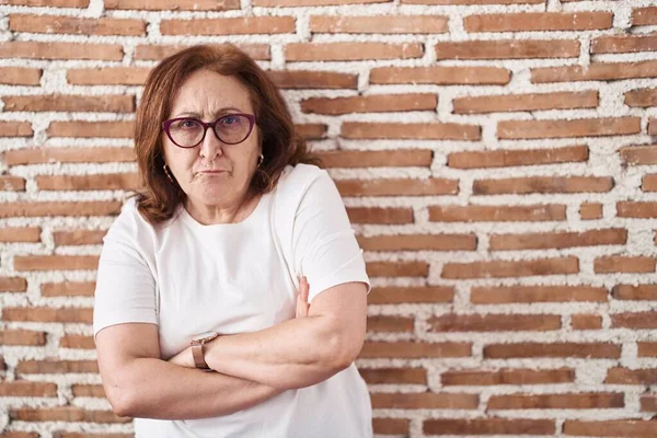 Ανώτερη Γυναίκα Γυαλιά Που Στέκεται Πάνω Από Τούβλα Τοίχο Σκεπτικιστής — Φωτογραφία Αρχείου