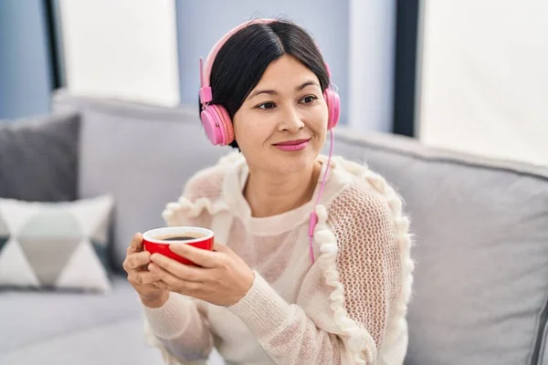 Young Chinese Woman Listening Music Drinking Coffee Home — Stockfoto