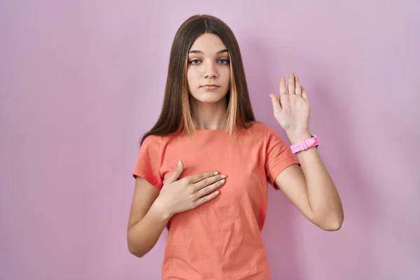 Nastolatka Stojąca Nad Różowym Tłem Przeklinająca Dłonią Piersi Otwartą Dłonią — Zdjęcie stockowe