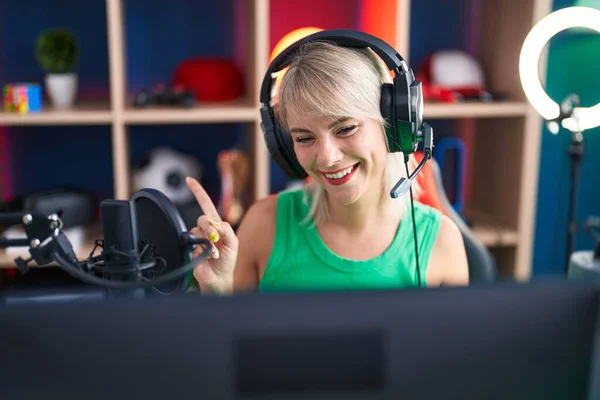 Mladá Běloška Hraje Videohry Sluchátkách Šťastným Úsměvem Ukazující Rukou Prstem — Stock fotografie