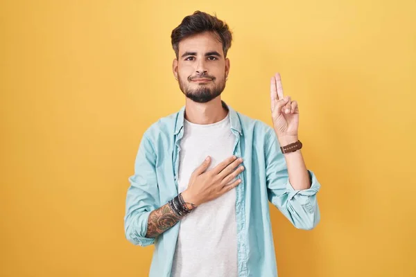 Ung Latinamerikan Man Med Tatueringar Står Över Gul Bakgrund Ler — Stockfoto