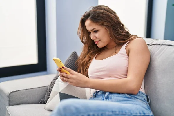 Mujer Hispana Hermosa Joven Usando Teléfono Inteligente Sentado Sofá Casa —  Fotos de Stock