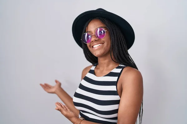 Молодой Африканский Американец Косичками Шляпе Солнцезащитных Очках Приглашает Войти Улыбающимся — стоковое фото