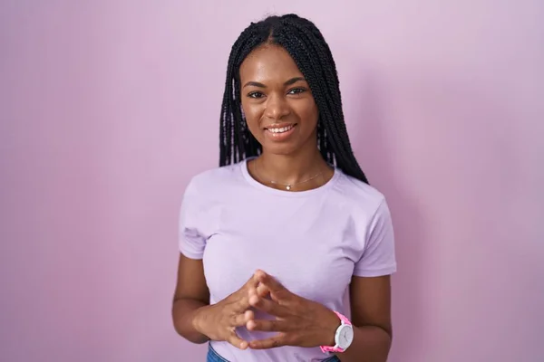 Африканская Американка Косичками Стоящими Розовом Фоне Скрещенными Пальцами Улыбаясь Расслабленной — стоковое фото