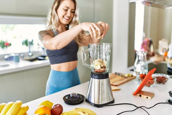 Young Woman Looking Online Juice Recipe Pouring Banana Blender Kitchen — Stok fotoğraf