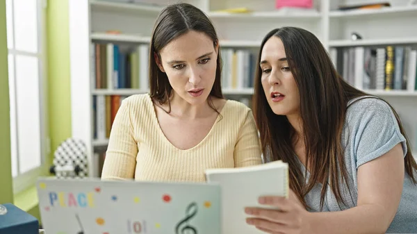 Duas Mulheres Sentadas Mesa Estudando Usando Livro Leitura Laptop Universidade — Fotografia de Stock