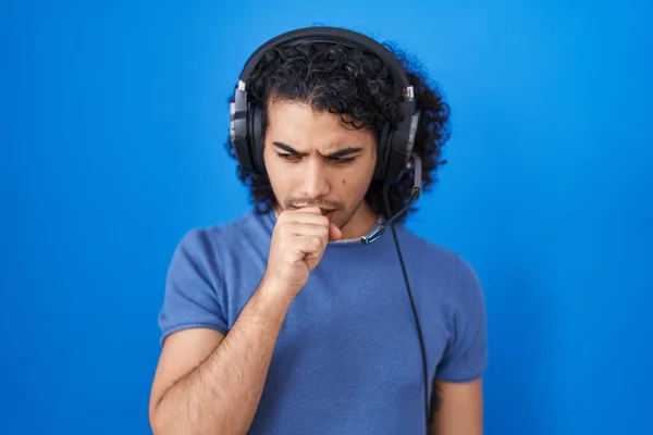 冷たいまたは気管支炎のための徴候としてヘッドフォンの感じのUnwellおよび咳を使用して音楽を聞いている巻き毛を持つヒスパニック系の男 ヘルスケアの概念 — ストック写真