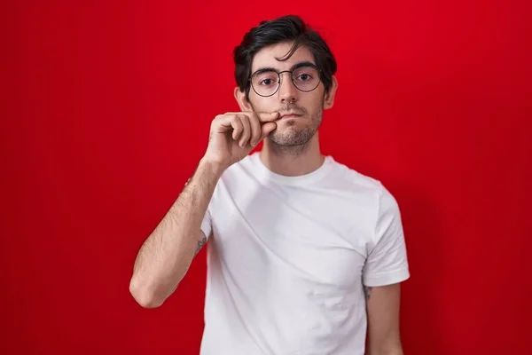 Kırmızı Arka Planda Duran Spanyol Genç Adam Ağzı Dudakları Parmaklarıyla — Stok fotoğraf
