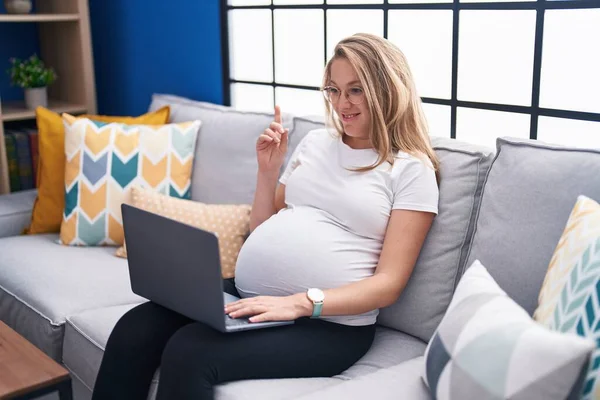 Mladá Těhotná Žena Sedí Doma Pohovce Používá Notebook Překvapený Nápadem — Stock fotografie