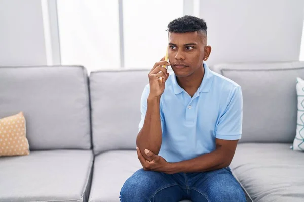 Genç Latin Adam Akıllı Telefonda Konuşuyor Evdeki Kanepede Oturuyor — Stok fotoğraf