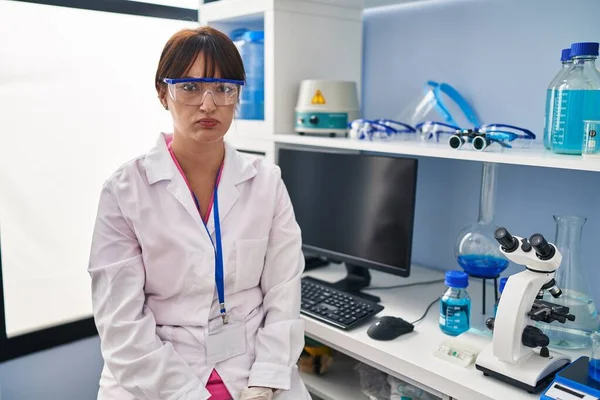 科学研究所で働く若いブルネットの女性は懐疑的で緊張し 問題のために動揺して眉をひそめています 否定的な人 — ストック写真