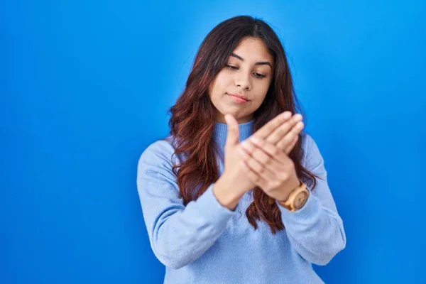西班牙裔年轻女子站在蓝色的背景上 手指头疼痛 关节炎发炎 — 图库照片