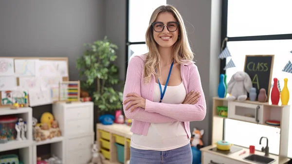 Young Blonde Woman Teacher Smiling Confident Standing Arms Crossed Gesture — Stockfoto