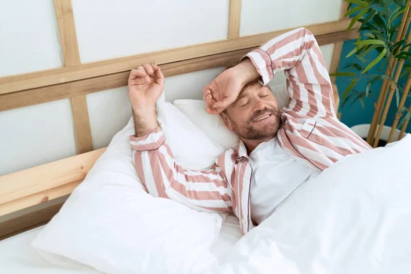 stock image Middle age man smiling confident lying on bed at bedroom