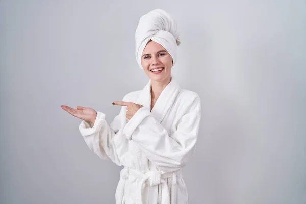 Blonde Caucasian Woman Wearing Bathrobe Amazed Smiling Camera While Presenting — Stock Photo, Image