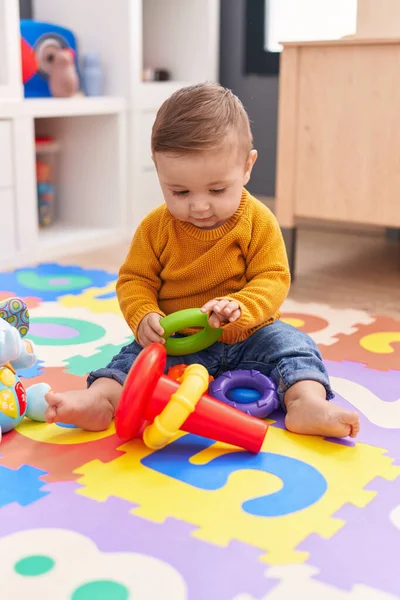 可爱的高加索婴儿在幼儿园的地板上玩铁环游戏 — 图库照片