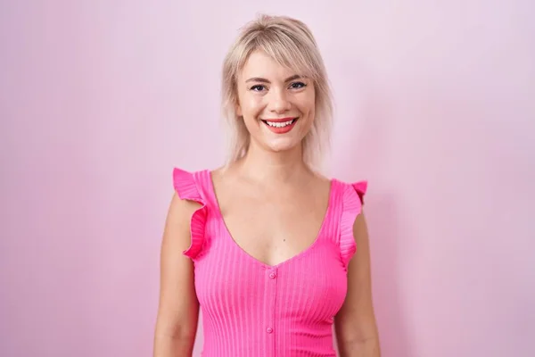 幸せとクールな笑顔でピンクの背景の上に立って若い白人女性 運のいい人 — ストック写真