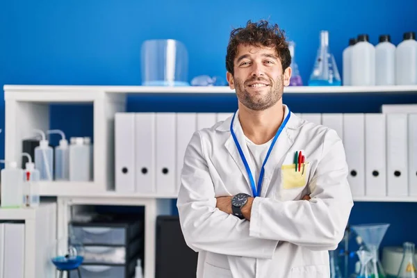 若いです男科学者笑顔自信を持って立ってとともに腕交差ジェスチャーで実験室 — ストック写真