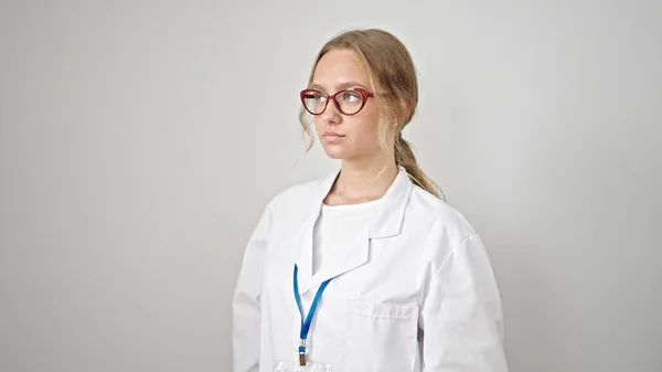 年轻的金发碧眼的女医生 带着严肃的表情 凝视着旁边孤立的白色背景 — 图库照片