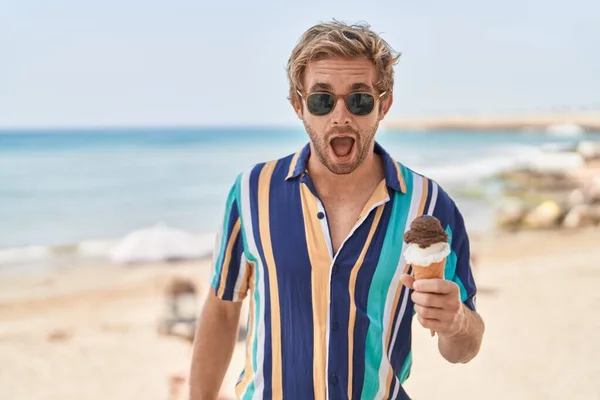白种人在海滩上吃冰淇淋时 吓得张大了嘴 惊慌失措 满脸诧异 — 图库照片